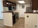 Compact kitchen featuring stainless steel appliances and dark wood cabinets at 8555 Fairmount Dr # A108, Denver, CO 80247