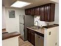 Galley kitchen with stainless steel fridge, dishwasher, sink, and wood cabinets at 8555 Fairmount Dr # A108, Denver, CO 80247