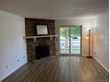 Bright living room with a stone fireplace and sliding glass doors to the outside at 8555 Fairmount Dr # A108, Denver, CO 80247