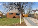 A cozy, one-story brick home featuring a well-manicured lawn and appealing curb appeal at 3550 Fairfax St, Denver, CO 80207
