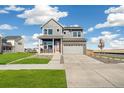 Charming two-story home with a well-maintained lawn and an attached two-car garage at 21295 E 61St Dr, Aurora, CO 80019