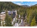 Overhead view of a grey mountain home surrounded by lush forest and mountain views at 379 Rainbow Rd, Idaho Springs, CO 80452