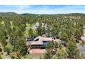 Aerial view of a spacious home with a pool surrounded by lush greenery at 2851 Interlocken Dr, Evergreen, CO 80439