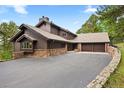 Striking exterior of home with stone accents, a large driveway, and an attached multi-car garage at 2851 Interlocken Dr, Evergreen, CO 80439