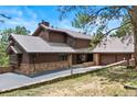Beautiful exterior of home with stone accents, a covered entrance, and attached garage at 2851 Interlocken Dr, Evergreen, CO 80439