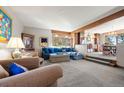 Spacious living room with comfortable seating, wood accents, and seamless transition into the dining area at 2851 Interlocken Dr, Evergreen, CO 80439