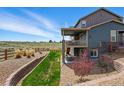 Spacious backyard featuring a covered deck, stone accents, lush lawn, and scenic views at 8086 S Grand Baker Way, Aurora, CO 80016