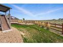 Expansive backyard with lush lawn, stone accents, wooden fence, and unobstructed views at 8086 S Grand Baker Way, Aurora, CO 80016