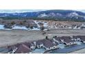 An aerial view of the homes situated in a valley, with a backdrop of snow-capped mountains at 4502 Echo Cliff Ln, Larkspur, CO 80118