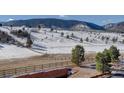 Scenic view of the landscape featuring trees and snow, with a rustic fence in the foreground at 4502 Echo Cliff Ln, Larkspur, CO 80118