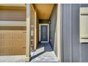 Home entryway featuring a covered porch and a 'HOME' sign by the garage at 7433 Ellingwood Cir, Frederick, CO 80504