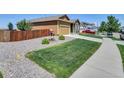 View of home from left side of property showing green lawn and rock landscaping at 7433 Ellingwood Cir, Frederick, CO 80504