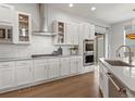 Well-equipped kitchen features white cabinets, stainless steel appliances, and tiled backsplash at 9378 E 60Th Pl, Denver, CO 80238