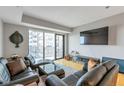 Bright living room featuring hardwood floors, sliding doors to balcony, and comfortable furniture at 2990 E 17Th Ave # 1102, Denver, CO 80206