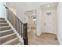 Inviting entryway with hardwood floors and a staircase leading to the upper level at 8205 Cokedale Cir, Littleton, CO 80125