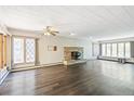 Spacious living room boasts hardwood floors, large windows, ceiling fan, and charming fireplace at 1680 S Patton Ct, Denver, CO 80219