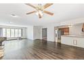 Expansive living room featuring hardwood floors, large windows, ceiling fan, and fireplace at 1680 S Patton Ct, Denver, CO 80219