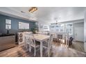 Dining room has stylish chandelier, white table set, accent wall, and beverage cooler at 12069 Monaco Ct, Brighton, CO 80602