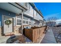Charming townhome featuring a stone facade, decorative door wreath, and private fenced-in front yard at 12069 Monaco Ct, Brighton, CO 80602