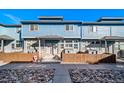 Exterior view of townhomes with blue siding, stone accents, and wood fences at 12069 Monaco Ct, Brighton, CO 80602