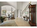 Elegant foyer with tiled floors, a staircase with iron railings, and a view into the living room with a fireplace at 4222 Serenade Rd, Castle Rock, CO 80104