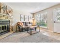 Comfortable living room showcasing a stone fireplace, plush sofa, and natural light from the window at 12059 E Hoye Dr, Aurora, CO 80012