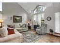 Bright living room with high ceilings, large windows, plush seating, and stylish décor at 6112 Alkire Ct, Arvada, CO 80004