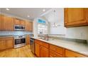 Bright kitchen with stainless steel appliances, wood cabinets, and a large window above the sink at 2238 Calais Dr # B, Longmont, CO 80504