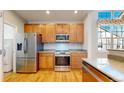 Open kitchen with stainless steel appliances, wooden cabinets, and hardwood floors at 2238 Calais Dr # B, Longmont, CO 80504
