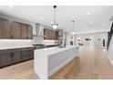 Bright, open kitchen featuring wood floors, a large island, stainless steel appliances, and access to living spaces at 1306 Yates St, Denver, CO 80204