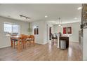 Open concept dining area adjacent to kitchen island with modern bar stools and wood flooring at 1651 Aspen Meadows Cir, Denver, CO 80260