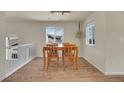 Bright dining area with wood floors, light-colored walls, and modern lighting fixtures at 1651 Aspen Meadows Cir, Denver, CO 80260