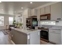Open-concept kitchen featuring granite countertops and modern black appliances at 13079 E 103Rd Pl, Commerce City, CO 80022