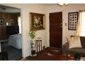 View of the living room showcasing a decorative painting, hardwood door, and open doorway to the bedroom at 5095 Grant St, Denver, CO 80216