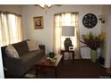 Living room featuring a neutral-toned sofa, decorative lighting, and tasteful decor at 5095 Grant St, Denver, CO 80216