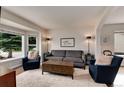 Cozy living room featuring large bay window, neutral paint, and comfortable seating arrangement at 11056 W Rowland Ave, Littleton, CO 80127