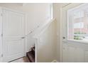 Bright entryway features white walls, staircase with dark wood steps, and door with window at 85 Uinta Way # 405, Denver, CO 80230