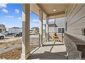 Cozy covered front porch with columns and outdoor seating and a view of the street at 24769 E 39Th Ave, Aurora, CO 80019