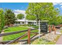 Landscaped front yard and a well-maintained exterior, complemented by a 'For Sale' sign at 2981 Teller St, Wheat Ridge, CO 80033