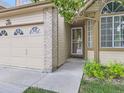 Close up of home showing front door, brick accents, and manicured landscaping at 6154 Quitman St, Arvada, CO 80003