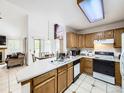 Bright kitchen with light wood cabinets, tile flooring, and plenty of counter space at 6154 Quitman St, Arvada, CO 80003