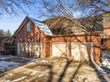 Attached four-car garage featuring brick facade and spacious driveway at 4681 S Columbine Ct, Cherry Hills Village, CO 80113