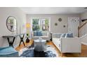Bright living room with hardwood floors, stylish decor, and natural light pouring in from large windows at 2867 Jasmine St, Denver, CO 80207