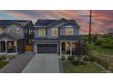 Charming two-story home with grey siding, solar panels, and a well-manicured lawn at dusk at 4585 High Mesa Cir, Castle Rock, CO 80108