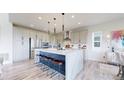 Modern kitchen with a large island, stainless steel appliances, and stylish pendant lighting at 4585 High Mesa Cir, Castle Rock, CO 80108