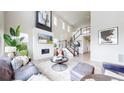 Bright, open living room with soaring ceilings, fireplace and an elegant staircase at 4585 High Mesa Cir, Castle Rock, CO 80108