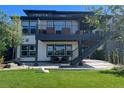 An inviting backyard with a covered patio, second-story deck, stone landscaping, and manicured lawn at 6610 Barnstead Dr, Castle Pines, CO 80108