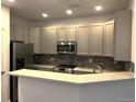 Modern kitchen featuring gray cabinets, stainless steel appliances, and a tiled backsplash at 11282 Osage N Cir # F, Northglenn, CO 80234