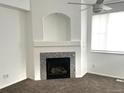 Cozy living room featuring a fireplace with decorative tile and a ceiling fan at 11282 Osage N Cir # F, Northglenn, CO 80234
