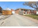 Front view of a brick ranch home with a driveway and gate at 1947 E 117Th Way, Northglenn, CO 80233